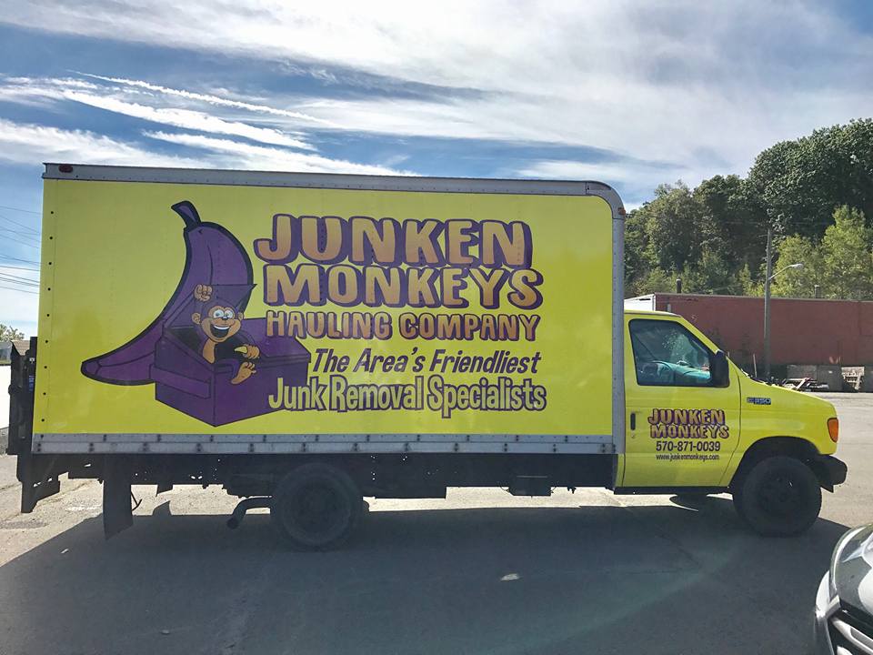 Yellow truck for "Junken Monkeys Hauling Company," labeled as "The Area's Friendliest Junk Removal Specialists," with a cartoon monkey and a banana on the side.